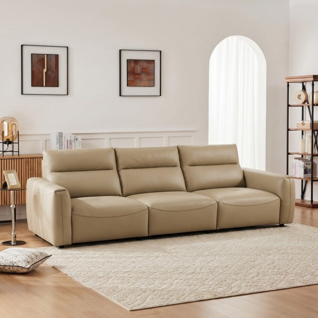 将浅卡其色皮质三人沙发自然融入提供的客厅背景中，移除背景中原有的白色沙发。沙发稳固落地，保持饱满填充的质感，光影与背景匹配：柔和漫射光从右侧拱形窗射入，在沙发底部生成自然的接触阴影，沙发表面反射环境的预览效果