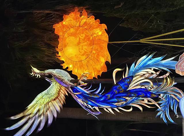 梦幻感与唯美感交织的国潮风插画，凤凰展翅于炽烈太阳前，光影流动间展现体积感与虚拟自然之美，融合浮世绘风格与霓虹灯风色彩。