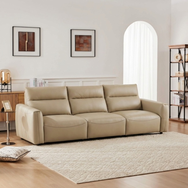 将浅卡其色皮质三人沙发自然融入提供的客厅背景中，移除背景中原有的白色L型沙发。沙发稳固落地，保持饱满填充的皮质质感，光影与背景完全匹配：柔和漫射光从右侧拱形窗射入，在沙发底部生成自然的接触阴影，沙发表预览效果